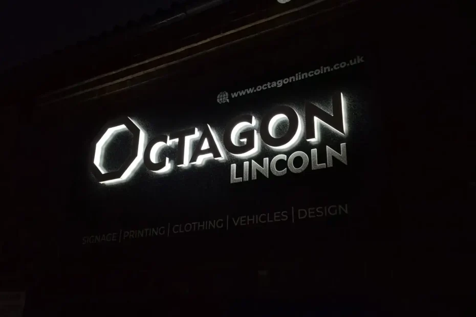Nighttime storefront of Octagon Lincoln with an illuminated logo sign on a dark building exterior.
